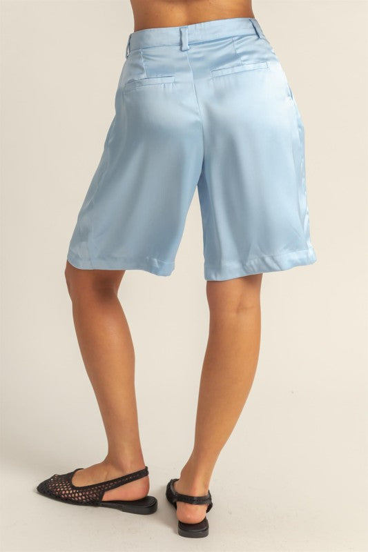 Elegant high-waist pleated satin shorts with a chic silhouette and luxurious finish, perfect for dressy or casual looks.