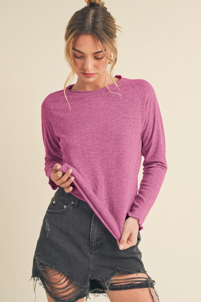 Stylish round neck raglan sleeve t-shirt with a unique lettuce hemline, perfect for a casual and chic look.