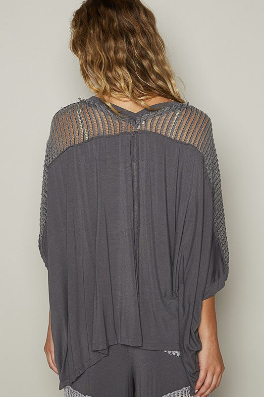 Women's oversized V-neck top with crochet lace contrast and studded details