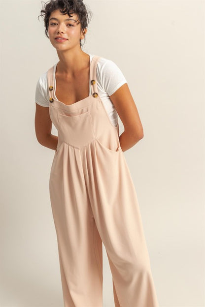 Trendy wide strap overalls with pleated details and front pockets for a stylish and comfortable look.