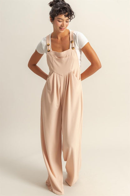 Trendy wide strap overalls with pleated details and front pockets for a stylish and comfortable look.