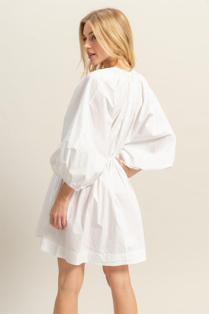 Plunge balloon sleeve poplin mini dress with pockets, a chic and playful statement piece.