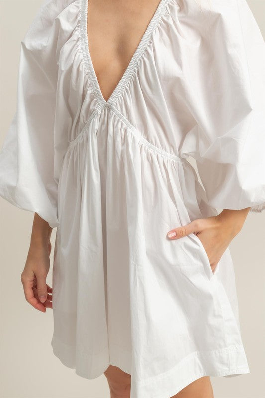 Plunge balloon sleeve poplin mini dress with pockets, a chic and playful statement piece.