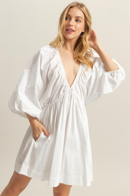 Plunge balloon sleeve poplin mini dress with pockets, a chic and playful statement piece.