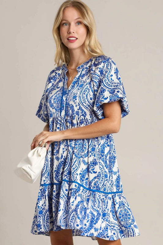 Chic printed mini dress with a notched neckline and puff sleeves, perfect for a trendy and stylish look.