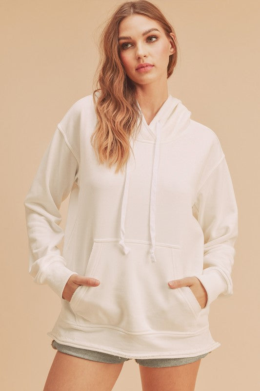 Stylish raw hem hoodie with a drawstring hood and kangaroo pocket, perfect for casual and trendy wear.