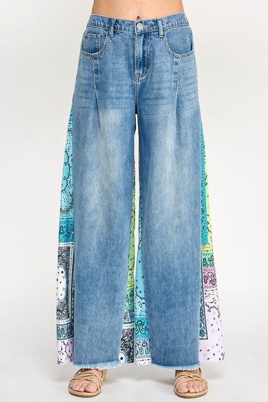 Trendy raw hem wide leg jeans with paisley print side panels, perfect for a vintage-inspired yet modern look.