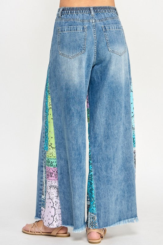 Trendy raw hem wide leg jeans with paisley print side panels, perfect for a vintage-inspired yet modern look.