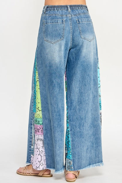 Trendy raw hem wide leg jeans with paisley print side panels, perfect for a vintage-inspired yet modern look.