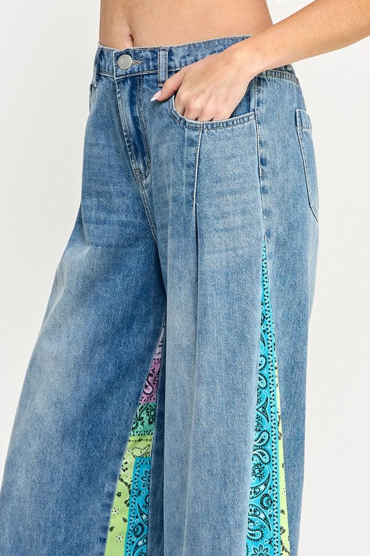 Trendy raw hem wide leg jeans with paisley print side panels, perfect for a vintage-inspired yet modern look.