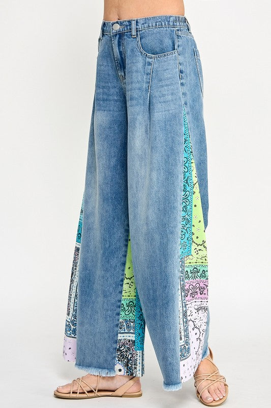 Trendy raw hem wide leg jeans with paisley print side panels, perfect for a vintage-inspired yet modern look.