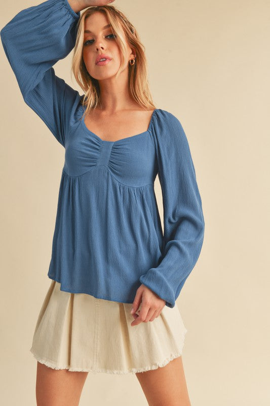 Elegant ruched sweetheart neck blouse with balloon sleeves, perfect for a chic and feminine look.