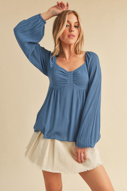 Elegant ruched sweetheart neck blouse with balloon sleeves, perfect for a chic and feminine look.