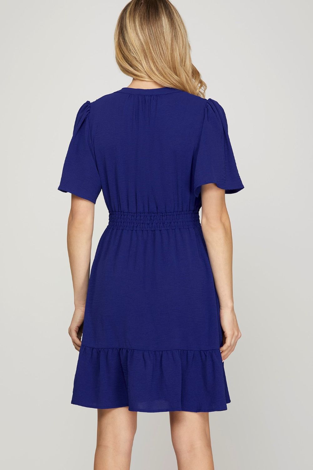 Chic ruffled hem notched flutter sleeve mini dress with a flattering smocked waist and romantic design.