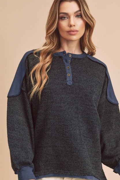 Trendy sweatshirt with side slits, button details, and contrast shoulder design, perfect for casual or athleisure wear.