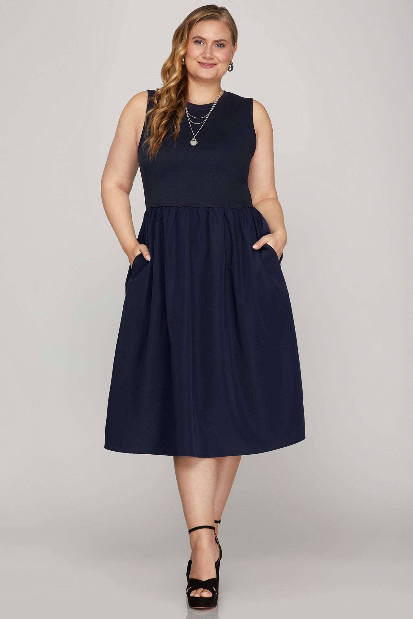 Chic sleeveless poplin midi dress with pockets, featuring a flattering A-line silhouette for effortless summer style.