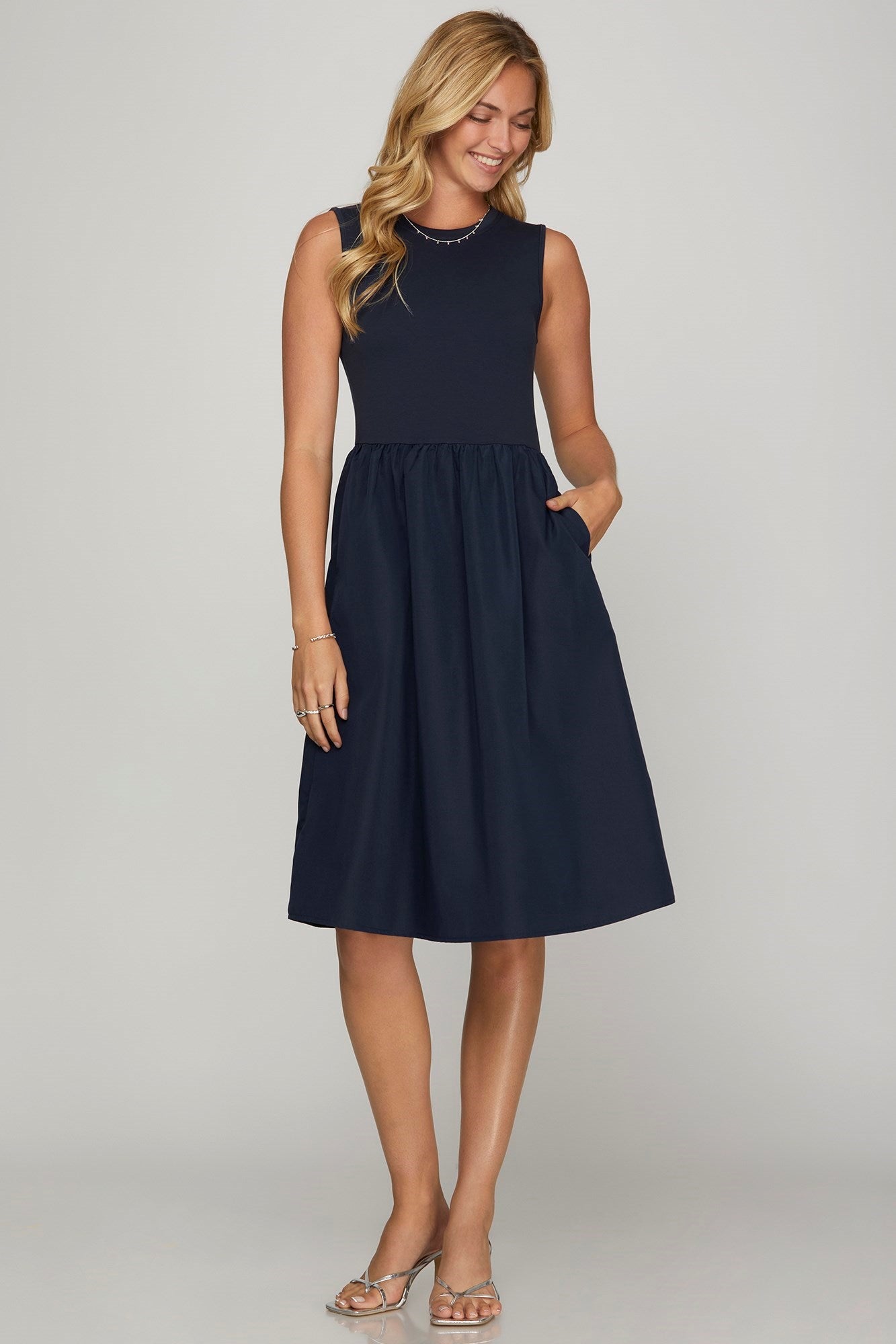 Chic sleeveless poplin midi dress with pockets, featuring a flattering A-line silhouette for effortless summer style.