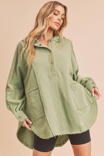 Trendy slit half-snap oversized hoodie with raw hem, ribbed cuffs, and pockets for a relaxed and stylish streetwear look.